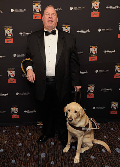 Michael Hingson in tux, with guide dog